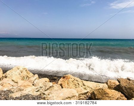 Rocky Sea Shore With Splaches Of Waves. Mediterranean Sea Coast. Seascape. Beautiful Day, Blue Sky, 