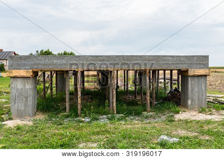 Reinforced Concrete Slab In The Shape Of A Rectangle On Concrete Poles. Visible Formwork And Buildin