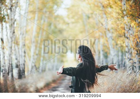 Dreamy Beautiful Girl With Long Natural Black Hair Flies On Bokeh Background Of Autumn Yellow Leaves