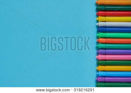 Border Of Colored Felt Tip Pens On Liht Blue Background With Place For Text. Top View