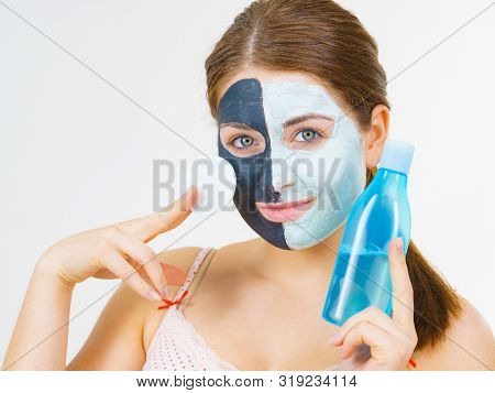 Woman With Clay Carbo Black Mask On One Half Face And White Mud On Second Half. Girl Removing Cosmet