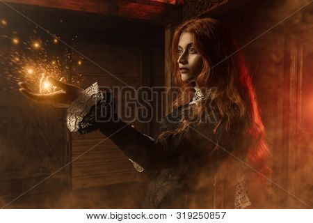 A portrait of a redhead scary witch  in her den. Magic, dark force, spell. 