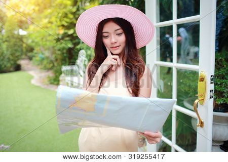 Young And Cute Asian Woman Searching Location In A Map During Holiday