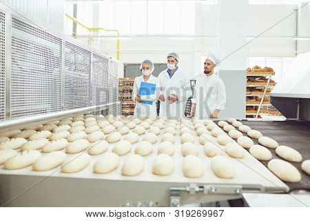 Technologist And Baker Inspect The Bread Production Line At The Bakery