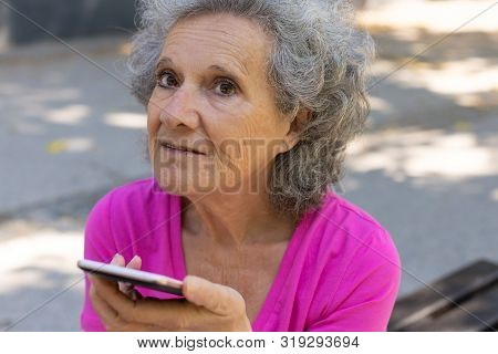 Pensive Excited Old Lady Using Speaker While Talking On Phone. Upset Senior Grey Haired Woman In Cas