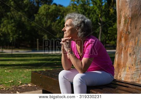 Thoughtful Lonely Old Lady Waiting Someone In Park. Senior Grey Haired Woman In Casual Sitting On Be