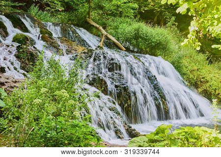 Photo Of The Waterfall, Taken At A Long Shutter Speed.blurred Water Flow, Sunlight, Lots Of Greenery