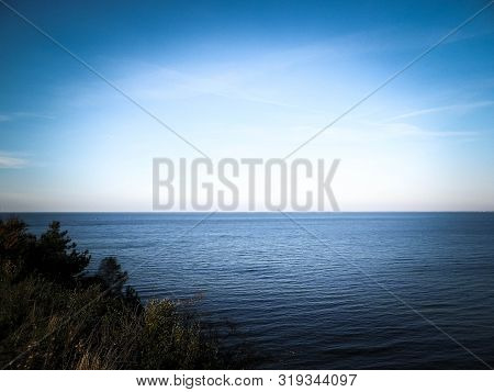Baltic Sea From Cliff In Mechelinki, Poland. Nature And Travel Concept. Copy Space On Blue Sky.
