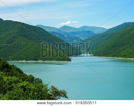Beautiful Landscape Overlooking A Large Blue Lake In The Mountains Covered With Forest.