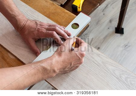 Installation Laminate Or Parquet In The Room, Worker Installing Wooden Laminate Flooring, Marking Th