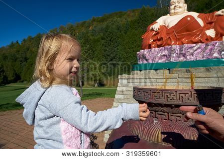 Harrington, Qc, Canada - September 23, 2018: In A Buddhist Temple, Tourists Lit Incense Sticks With 