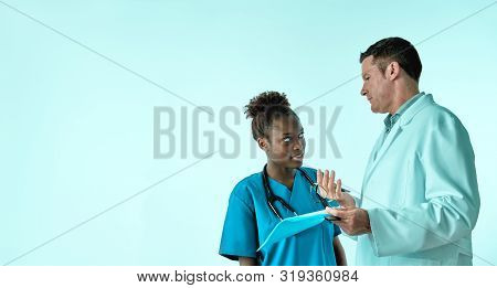 Doctor Explains To The Nurse Treatment Pllan For A Patient, Two Professionals, Seinor White Male And