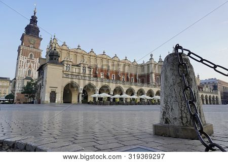 Empty Market Square In Krakow In The Early Morning. Revival Of City Pigeons Walking On The Pavement