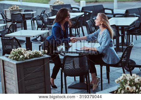Two Cooperative Workers Are Disscussing New Project Outside Office, At Caffeteria At Nice Summer Day