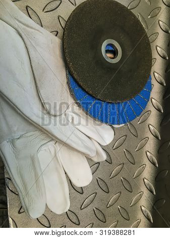 Grinding Wheel With Gloves On Metal Background