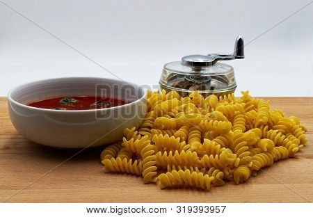 Italian Uncooked Fusilli, Italian Pasta, Tomato Soup With Basil, Nutmeg Shredder. Wooden Table, Whit