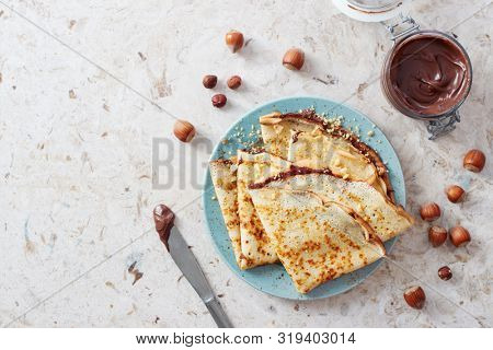 Homemade crepes, tasty thin pancakes with chocolate and nuts. 