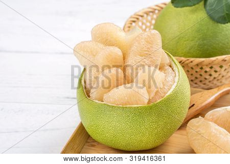 Fresh Peeled Pomelo, Grapefruit, Shaddock With Green Leaf On Bright Wooden Plank Table. Seasonal Fru