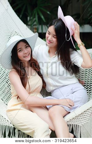 Young And Cute Asian Women With Hat Lying In A Hammock During Holiday