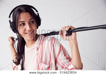 Female Sound Recordist Holding Microphone On Video Film Production In White Studio