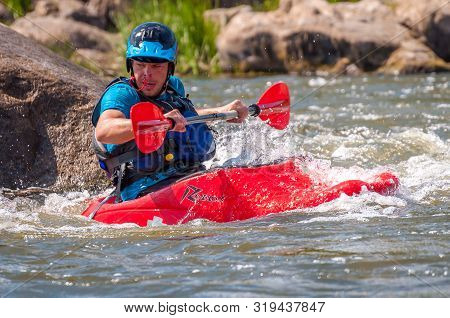 Myhiya, Ukraine - August 17, 2019: Playboating. A Man Sitting In A Kayak With Oars In His Hands Perf