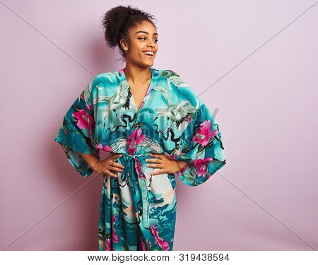 Young beautiful african american woman standing wearing elegant colorful caftan