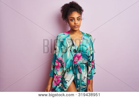 Young beautiful african american woman standing wearing elegant colorful caftan