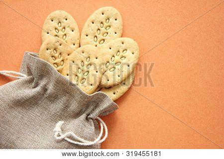 Reusable Canvas Bag And Multicereal Biscuits On Brown Background . Care For The Environment And Heal