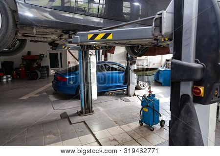 Used Carraised On A Lift For Repairing The Chassis And Engine In A Vehicle Repair Shop. Auto Service