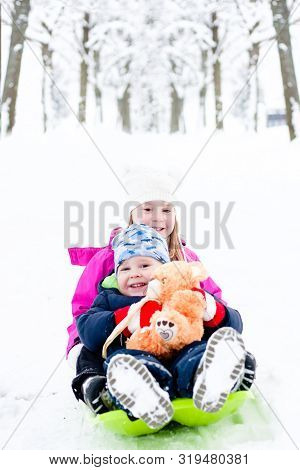 Preschool Age Siblings Go On Bobsled In Winter Time.