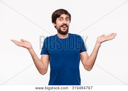 Good Looking Brunet Man In A Blue Shirt With Beard And Mostaches Shrugging His Shoulders Being Cluel