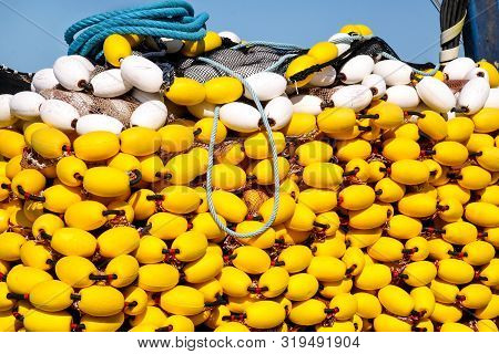 Yellow Floats On The Pile, Covering Fishing Nets On The Blue Boat In The Summer Sun, Close Up. Fishi
