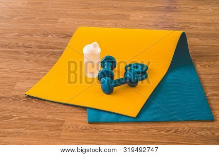Water, Sports Blue Dumbbells At Karemat In The Gym. Sport Accessories. Sport Equipment Top View Back