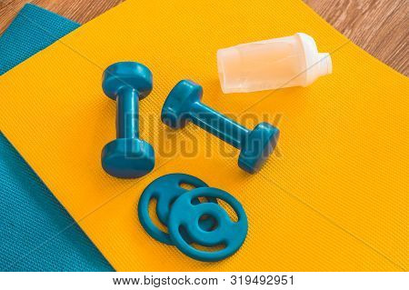 Water, Sports Blue Dumbbells At Karemat In The Gym. Sport Accessories. Sport Equipment Top View Back