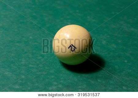 One Ivory White Billiard Balls On A Green Pool Table. Nomber 12.