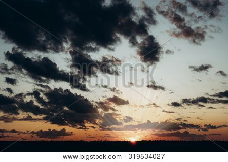 Evening Sky At Sunset Background. Dark Clouds Hanging Above Horizon. Majestic Cloudscape In Blue, Or