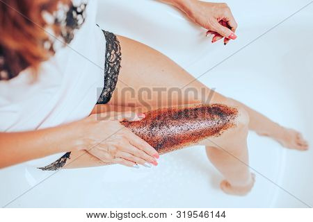 Slim Young Woman In A Bright Silk Pajamas Scrabs Her Leg Sitting In A Big Beautiful Bright Bath. Ski