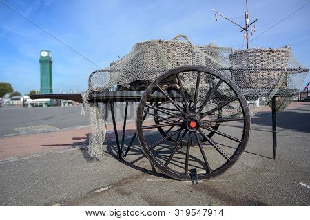 Old Wooden Fishing Cart With Crab Baskets Covered With A Net At The Market Place In Buesum On The No