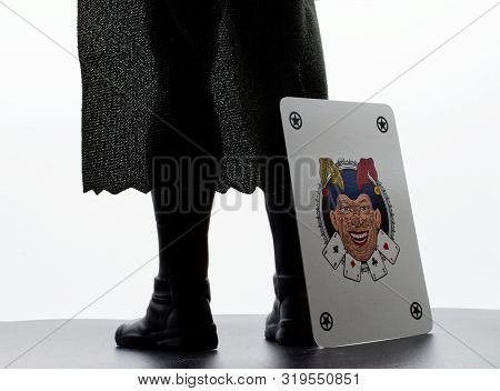 Bologna / Italy August 29, 2019: A Joker Playing Card Next To A Batman Action Figure, On White Backg