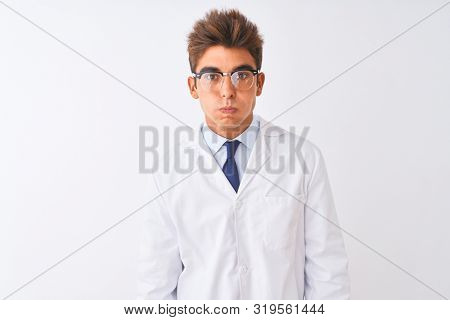 Young handsome sciencist man wearing glasses and coat over isolated white background puffing cheeks with funny face. Mouth inflated with air, crazy expression.