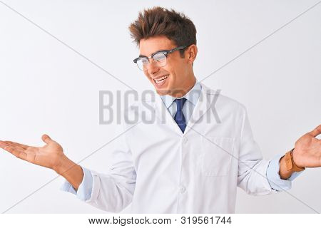 Young handsome sciencist man wearing glasses and coat over isolated white background smiling showing both hands open palms, presenting and advertising comparison and balance