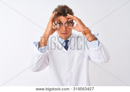 Young handsome sciencist man wearing glasses and coat over isolated white background Trying to open eyes with fingers, sleepy and tired for morning fatigue