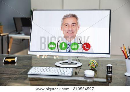 Doctor Smiling While Video Conferencing On Computer In Hospital