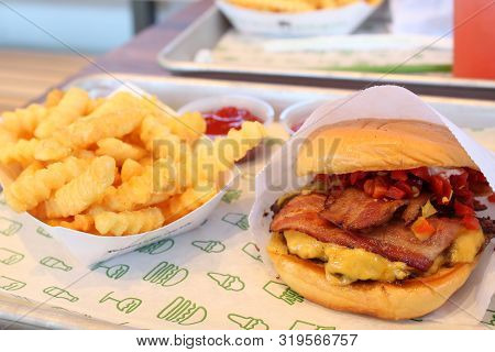 Shake Shack Cheeseburger With Bacon And Cherry Peppers On A Soft Buttery Bun With Crinkle Cut Fries 