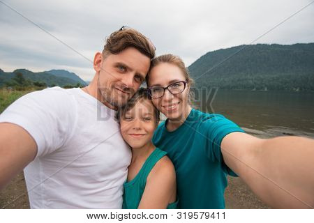 Selfie of family on the Teletskoye lake in Altai mountains, Siberia, Russia. Beauty summer day.