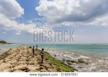 Kuta, Indonesia - October 21, 2018: Boys Fishing On The Pier Of Seminyak On Bali, Indonesia