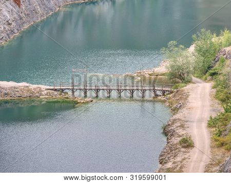 Green Blue Lake With Wooden Tourist Path Bridge Above Cold Water. Hiking In The National Park