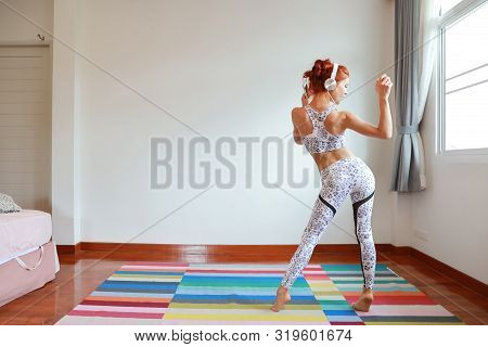 Back View Portrait Of Young Attractive Caucasian Woman In Black And White Sportswear Who Listening A