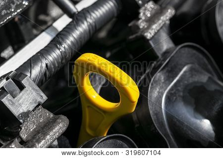 Yellow Oil Dipstick In Car Engine. Measuring Level Of Engine Oil. Dipstick Oil Level Gauge With Yell
