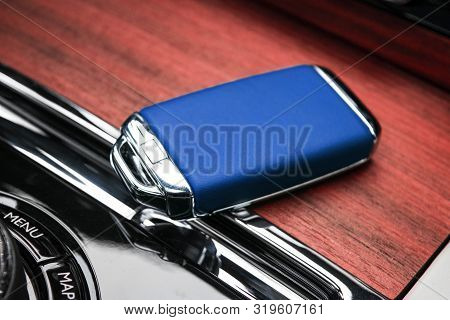 Closeup Inside Vehicle Of Wireless Blue Leather Key Ignition On Natural Wood Panel. Wireless Start E